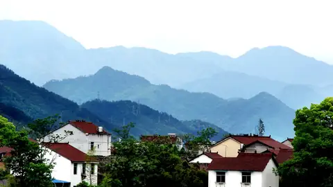 Imagem ilustrativa: China: Casas em montanhas com paisagem azul