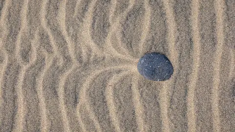 Imagem ilustrativa: Espanha: Pedra em areia com ondas