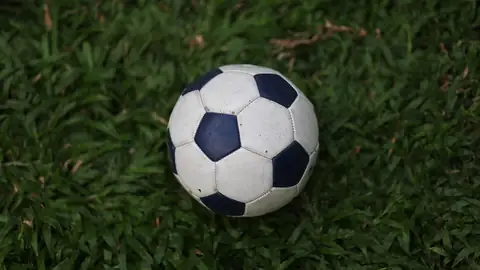 Imagem ilustrativa: Bola de futebol em grama verde