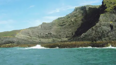 Imagem ilustrativa: Irlanda: Costa rochosa com mar azul e céu claro