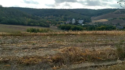 Imagem ilustrativa: Moldávia: Campo e montanhas com construção distante