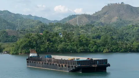 Imagem ilustrativa: Filipinas: Barco de carga em lago com montanhas