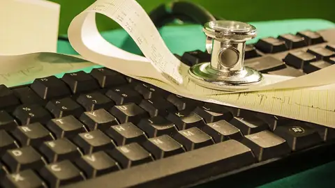 Imagem ilustrativa: Teclado com estetoscópio e papel