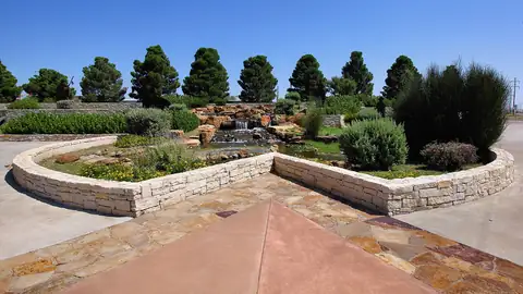 Imagem ilustrativa: Texas: Jardim com fonte e árvores sob céu azul